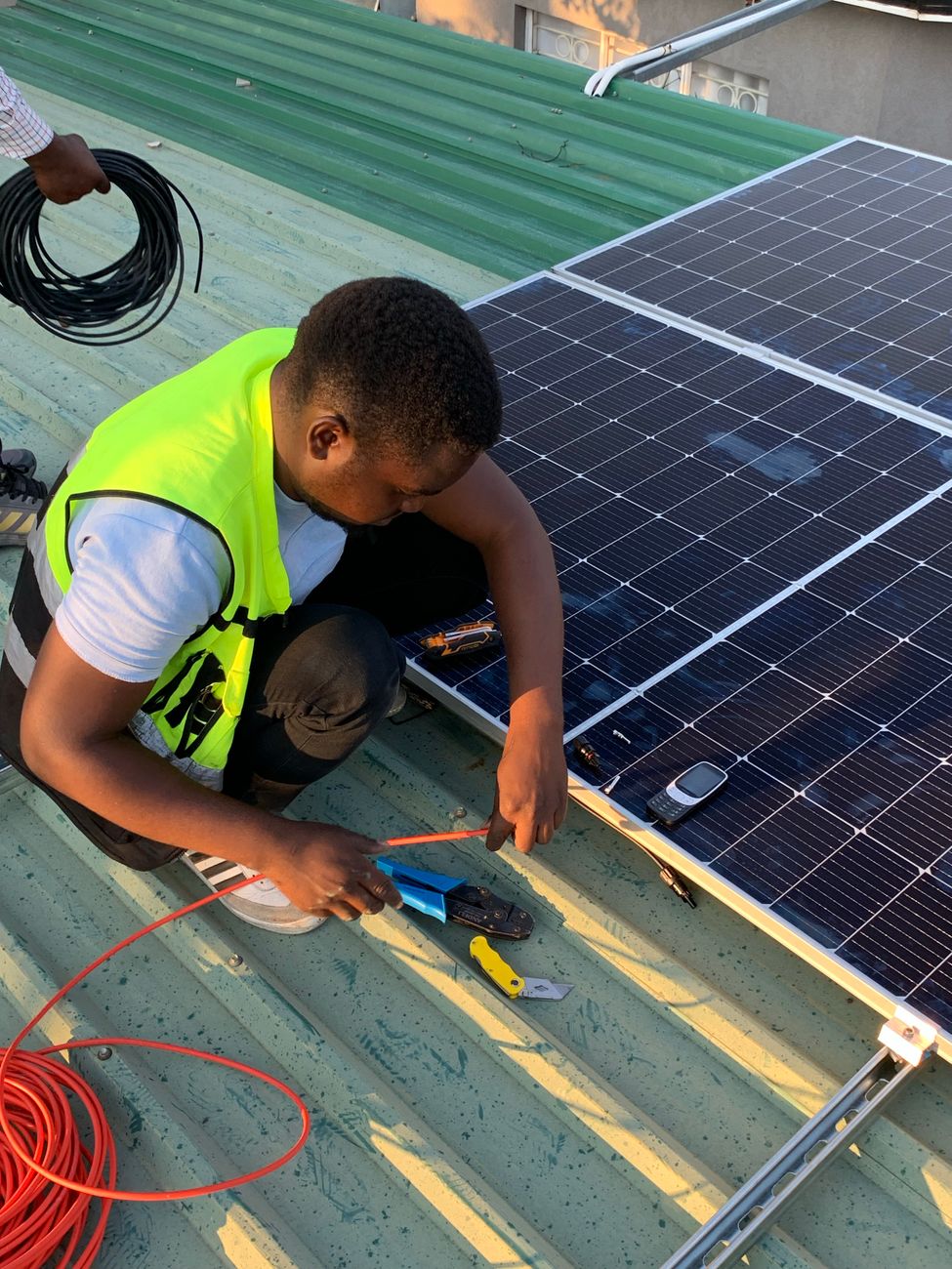 technician installing solar panels on rooftop